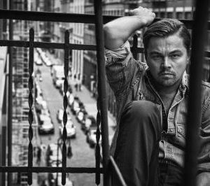 Leonardo Dicaprio, New York, NY, 2015 by Mark Seliger, the actor in a jeans shirt sitting on a cast iron balcony above a street