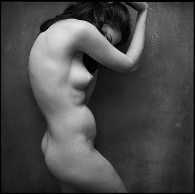 Nude by Mark Seliger, nude model in profile, hiding her face behind her arm