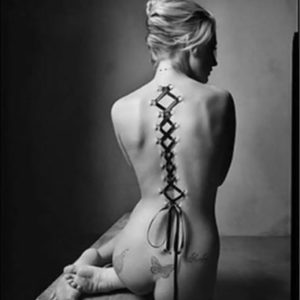 Nude Corset by Mark Seliger, nude model with piercings on her back, laced together like a corset