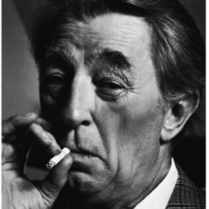 Robert Mitchum by Timothy White, black and white portrait of the actor in a chekcered suit smoking