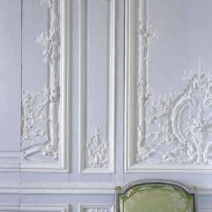 White wall with baroque stucco decor, 'invisible' servants door and green and silver embroidered chair