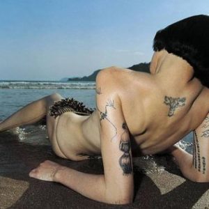 Brazilich by Rankin, tattooed nude model lying on the beach