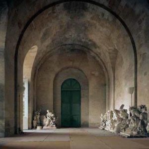 L'Orangerie by Robert Polidori, collonade with green door and marble statues in storage