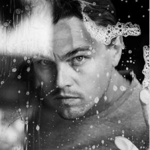 Leonardo DiCaprio, by Nigel Parry, black and white Portrait of the actor looking through a soapy window