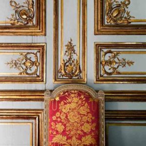 Salon des jeux Louis XVI, red and gold embroidered chair in front of white and gold stucco wall