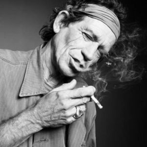 Smoking Keith Richards by Rankin, black and white portrait of the musician in shirt and headband, with a cigarette