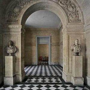 Vestibule de l'escalier Louis-Philippe, Chateau de Versailles, 1985 by Robert Polidori, stone arc with floral decor, two busts and checkerboard patterned floor