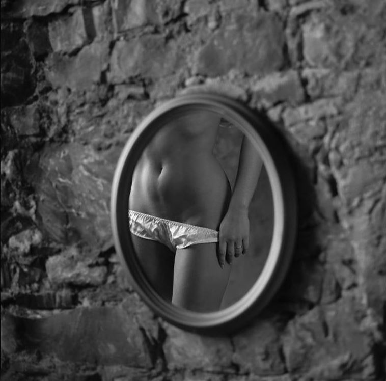 Gaias Panties by Guido Argentini, mirror reflection of a model pulling down white panties