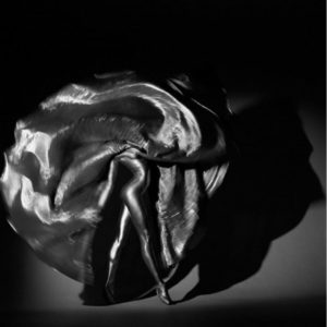 Inanna by Guido Argentini, silver painted dancer twirling with silver pleated skirt