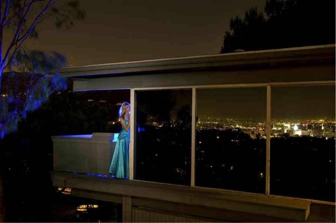 Waiting for Love by Guido Argentini, model in turquoise gown standing on a terrace