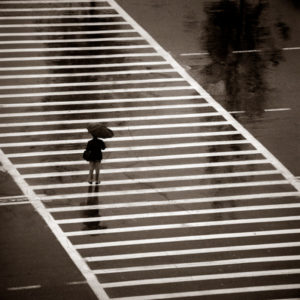 Crosswalk - Beijing Hilton 1979 by albert watson, a single person with an umbrella on a crosswalk