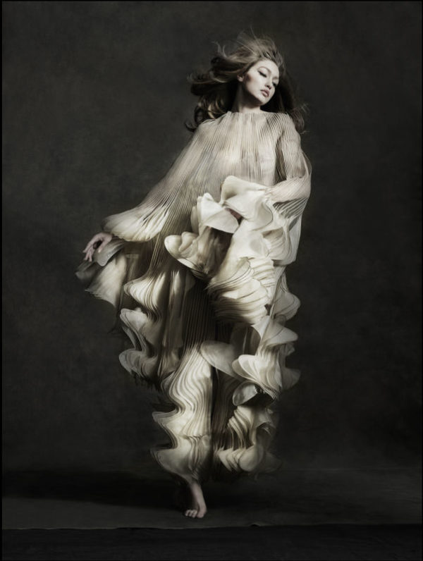 Gigi Hadid - Iris Van Herpen - New York City 2019 by ALbert Watson, the model in a white ruffled cape gown jumping