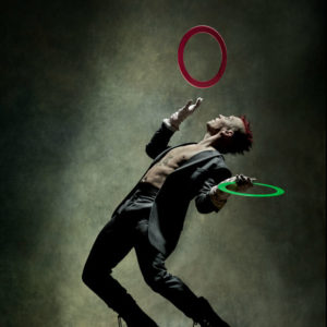 Josh Dean - Zoo Magazine - NYC 2020, mal in a grey suit and red deathhawk juggling colorful rings