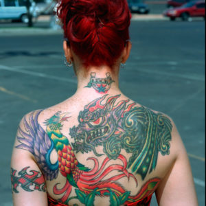 Linda Husjord - Las Vegas 2001, back of a woman with a dragon and bird tattoo on her back, wearing a red dress and updo, standing in a parking lot