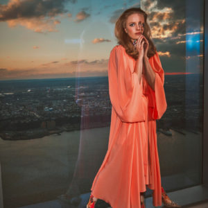 Hadley Robinson II by Guy Aroch, the actress in an orange gown on a rooftorp terrace
