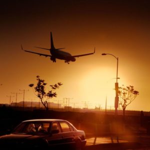 Airport Lovers by David Drebin, a landing airplane in the sunset