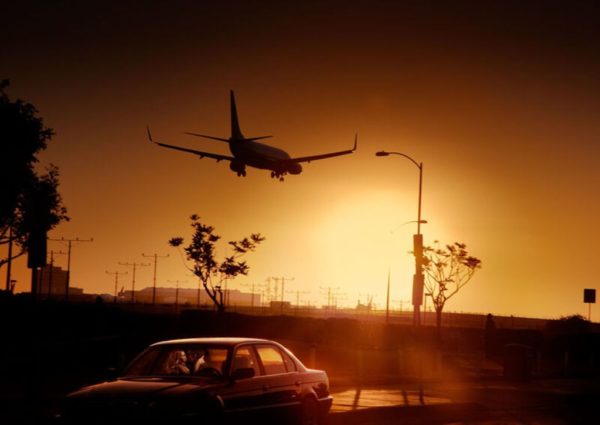 Airport Lovers by David Drebin, a landing airplane in the sunset
