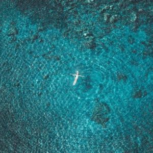 Floating Dreams Diamond Dust by David Drebin, model floating in the turquoise ocean