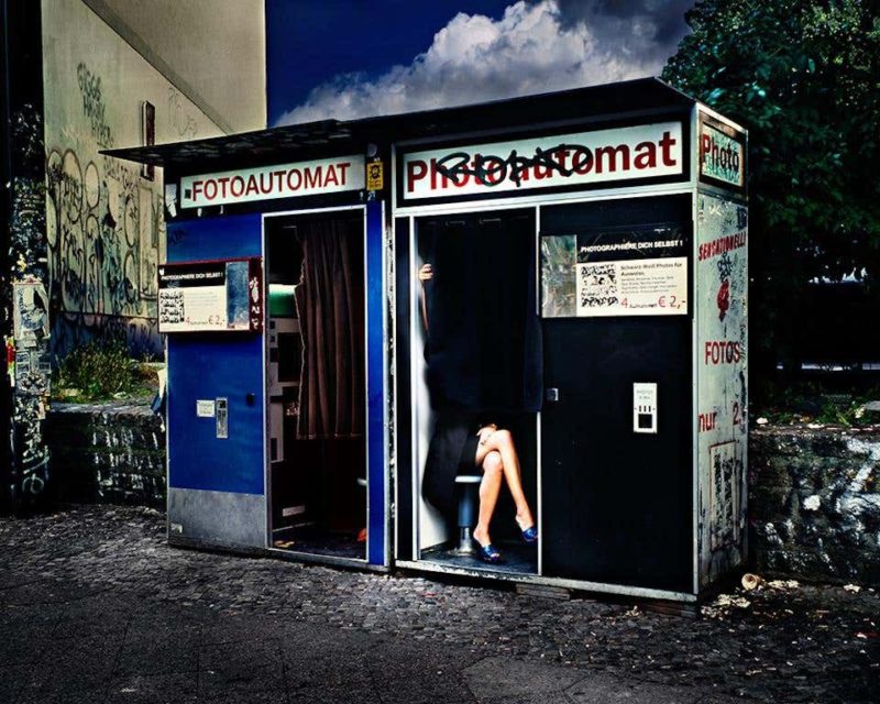 Legs in Berlin by David Drebin, model sittig in a photobox, only her legs in blue heels sticking out