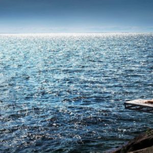 Kissing the sky by David Drebin, nude model lying on boat jetty over the ocean