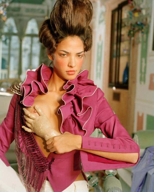 Casanova by Iris Brosch, Model in pink frilly top and updo, covering her exposed breast with a statue hand