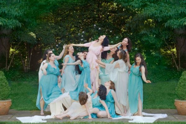 Duncan by Iris Brosch, a group of women in white blue and pink greek inspired gowns posing in a garden looking up