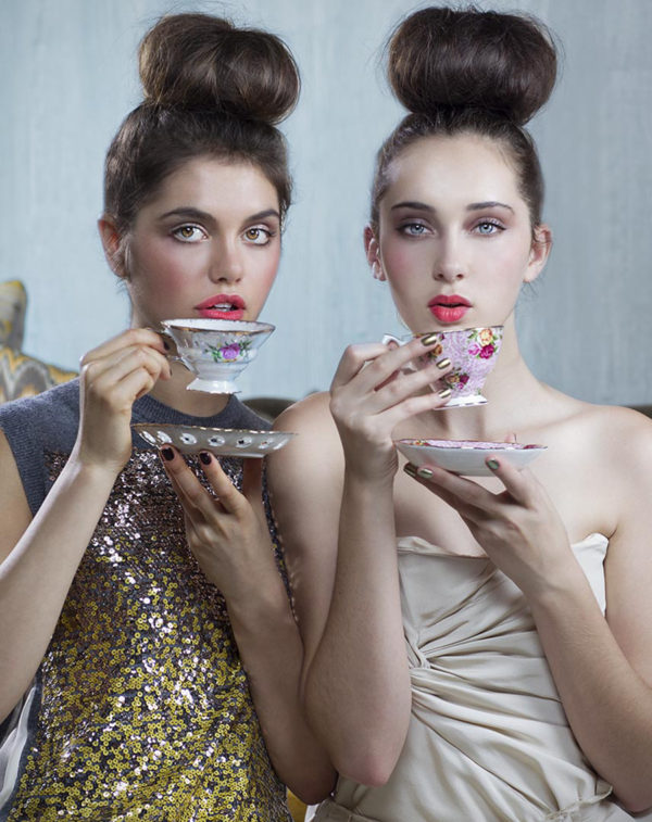 Untitled V by Iris Brosch, two models with high topknots and pink lips drinking from antique teacups with flower decor