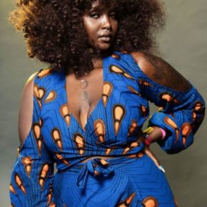 Barbara Simi Muhumuza, portrait of the influencer wearing a blue and orange dress and natural hair