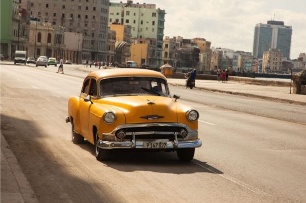 Cuba by Marc Baptiste, yellow chevrolet oldtimer on the street at cubas harbor