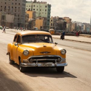 Cuba by Marc Baptiste, yellow chevrolet oldtimer on the street at cubas harbor