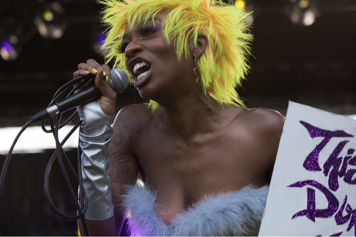 Junglepussy by Marc Baptiste, portrait of the rapper wearing yellow heair and a feather bustier performing at the 2019 afropunk festival