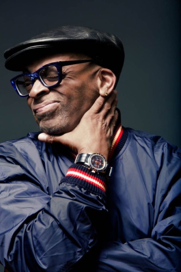 Spike Lee ROLEX by Marc Baptiste, portrait of the director and actor in a blue jacket and glasses with a black leather heat showing off a rolex watch