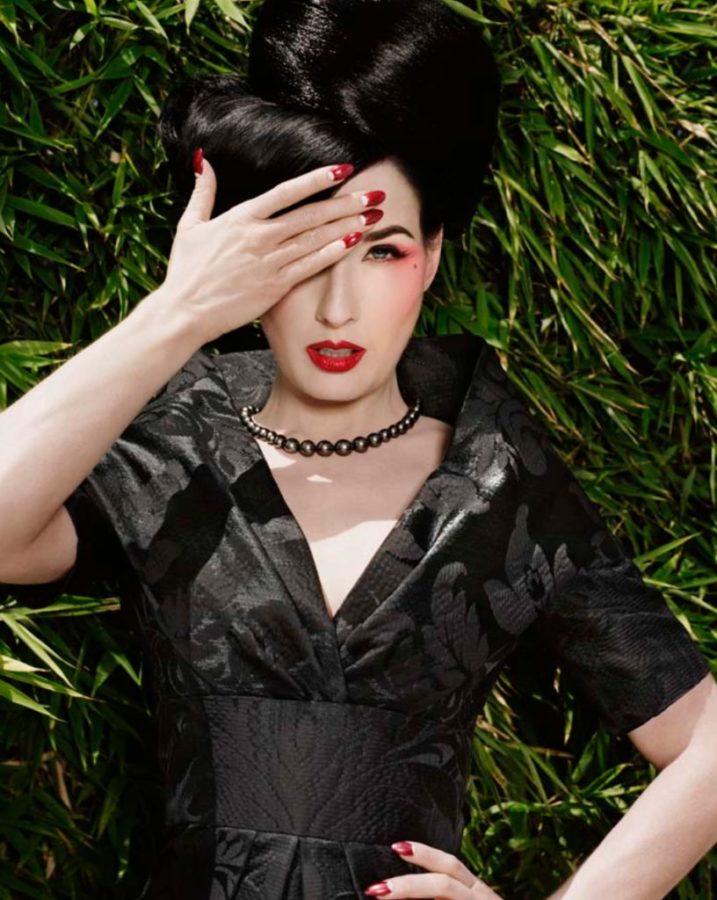 Untitled VI by Marc Baptiste, Portrait of Dita van Teese in black dress and updo, covering one of her eyey, standing in front of bamboo plants