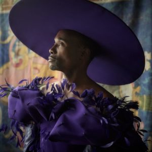 Billy Porter by Mark Seliger, portrait of the actor in a huge purple hat and purple feather dress
