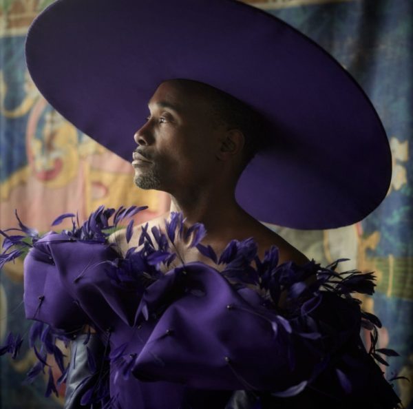 Billy Porter by Mark Seliger, portrait of the actor in a huge purple hat and purple feather dress