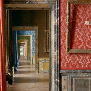 Cadre Vide, Chateau de Versailles by Robert Polidori, baroque enfilade with marble doorframes and red yellow blue and green wallpaper, an empty gold frame in the foreground
