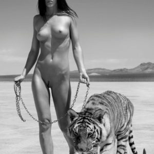Ashley walks the Tiger by Sylvie Blum, nude model holding a tiger on a chain in the desert