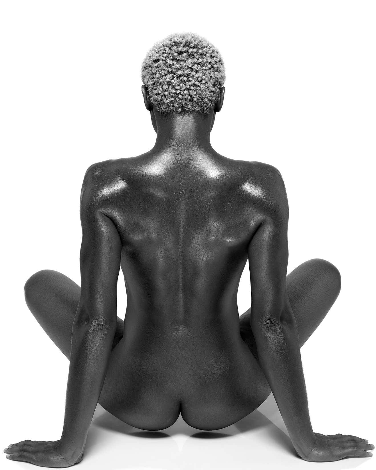 Female Buddha by Sylvie Blum, black model from the back, sitting crosslegged