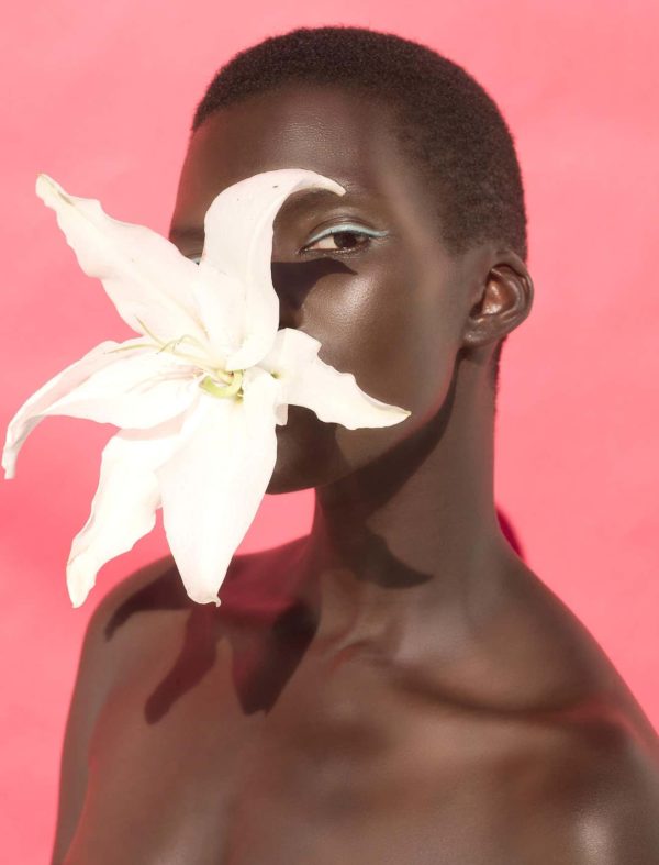 Flower Two by Sylvie Blum, black model with turquoise eyeliner and a white Lily in her mouth