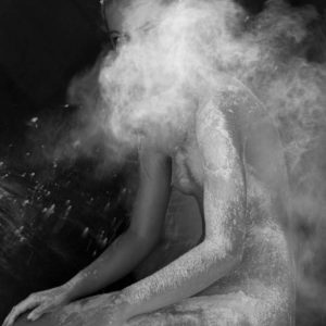 Leila in the cloud by Sylvie Blum, nude model kneeling covered in white dust, a dustcloud covering her face