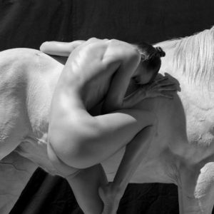 Palms Spring Two by Sylvie Blum, nude model bending next to a white horse, in balck and white