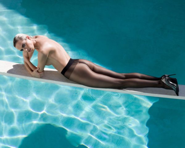 World of two by Sylvie Blum, model in tights and heels lying on a wooden panel over a pool