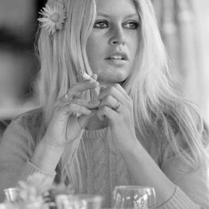 Brigitte Bardot Shalako by Terry O'Neill, the model with a flower in her hair and a cigarette in hand, in front of her glasses
