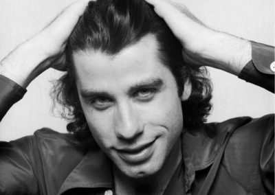 John Travolta by Terry O'Neill, black and white portrait of the actor with his hands in his hair