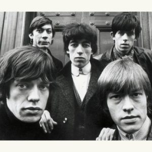 The Rolling Stones by Terry O'Neill, black and white portrait of the band in fornt of a wooden door
