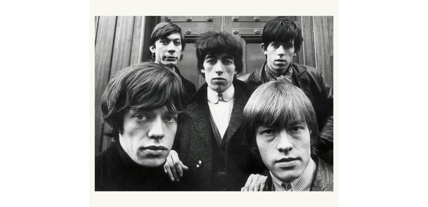 The Rolling Stones by Terry O'Neill, black and white portrait of the band in fornt of a wooden door