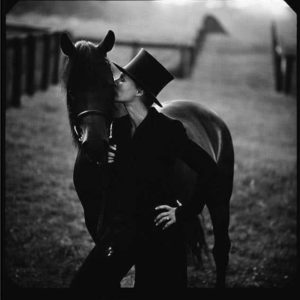 Glenn Close by Timothy white, the actress in black suit and tophat kissing a horse