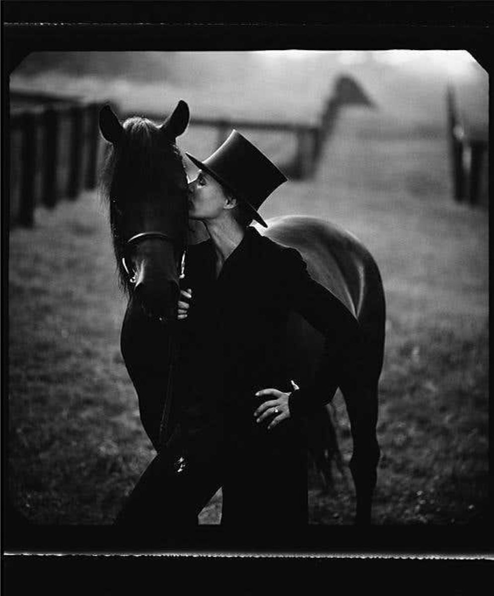 Glenn Close by Timothy white, the actress in black suit and tophat kissing a horse