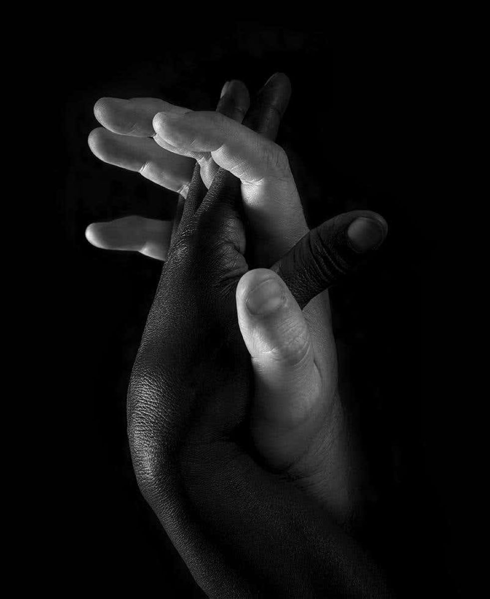 Hands 'One' Black & White by Timothy White, a white and a black hand intertwined