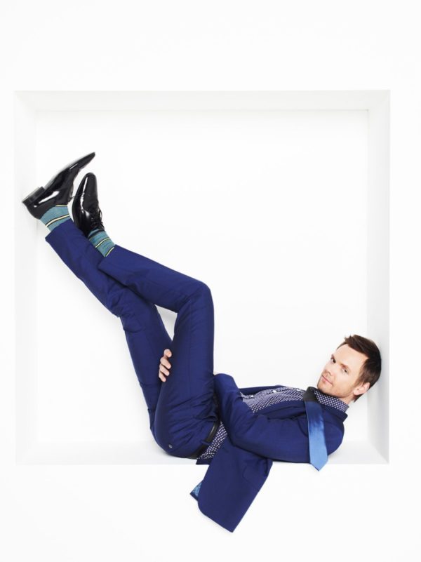 Joel Mchale by Timothy White, the actor in a blue suit lying in a white box